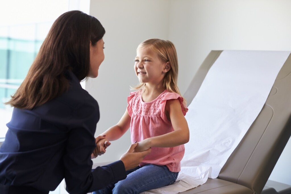 Young happy girl getting an autism evaluation for a healthcare professional
