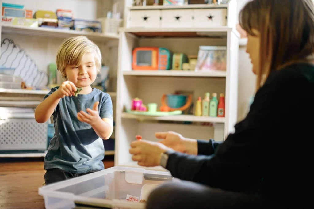 ABA therapist working one-on-one with a young autistic child during a play-based therapy session.