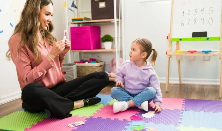 ABA therapist working with a young autistic child during therapy.